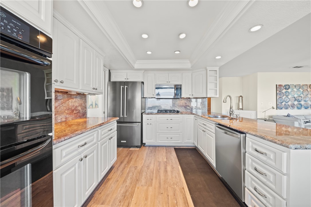 6607 New Ridge Drive Riverside, CA 92506 - Photo 12 of 46 a kitchen with stainless steel appliances granite countertop refrigerator a sink dishwasher a stove and white cabinets with wooden floor