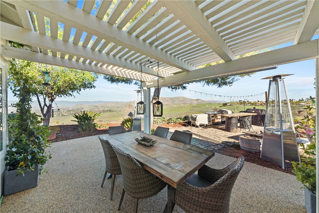 6607 New Ridge Drive Riverside, CA 92506 - Photo 31 of 46 a view of a patio with a table and chairs and couches with wooden floor and fence