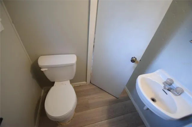 a view of an empty room with wooden floor and window