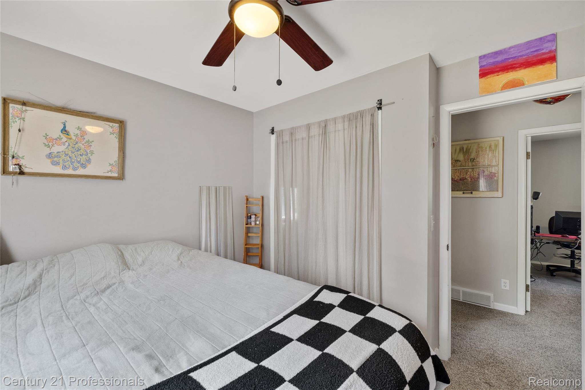 15037 Hogan Road Linden, MI 48451 - Photo 24 of 38 Bedroom featuring light gray walls, a window with sheer curtains, a ceiling fan with integrated lighting, and an open doorway revealing carpeted flooring