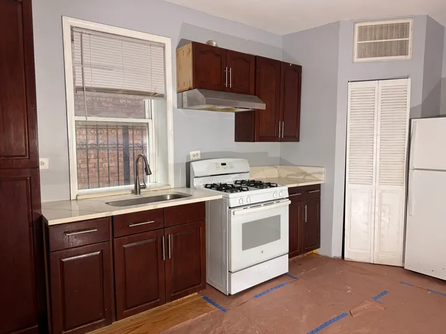 a kitchen with a refrigerator sink and cabinets