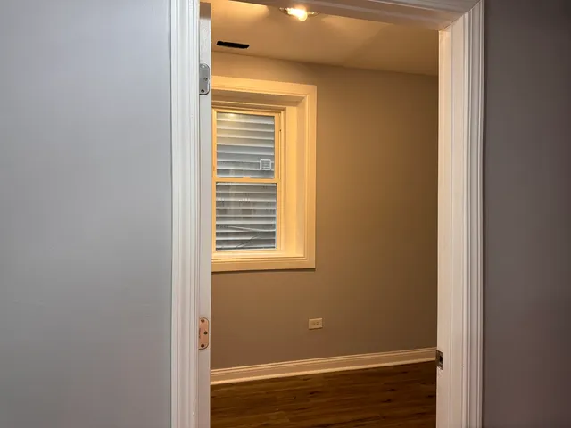 a view of a hallway with a livingroom and a bathroom with sink mirror
