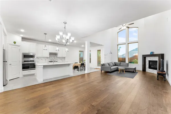 a large white kitchen with a large window a couch and a dining table