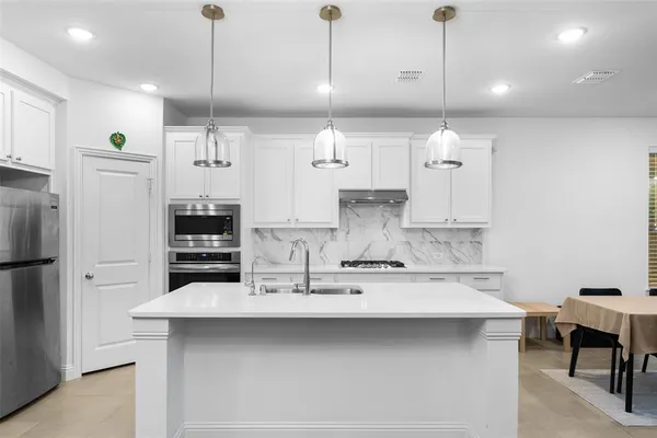 a kitchen with refrigerator and chairs