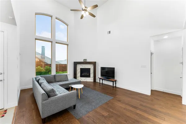 a living room with furniture a fireplace and a floor to ceiling window