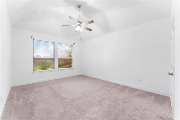 an empty room with windows and fan