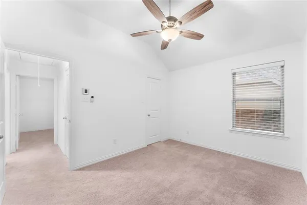 an empty room with a window and a fan