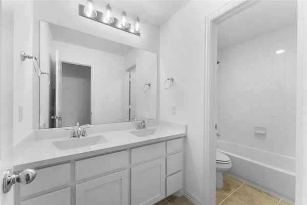 a bathroom with a sink double vanity granite tub and shower