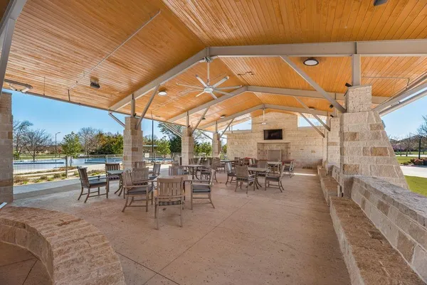 a view of a patio with dining table and chairs under an umbrella