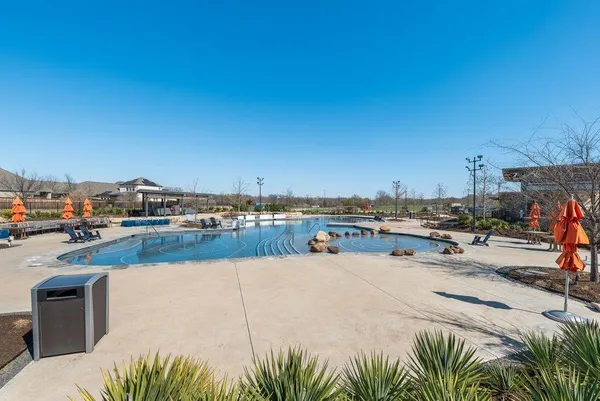 a view of swimming pool with outdoor seating and plants