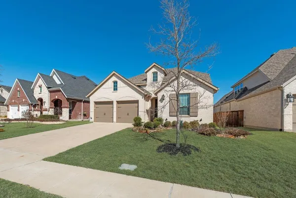 a front view of a house with a garden and trees