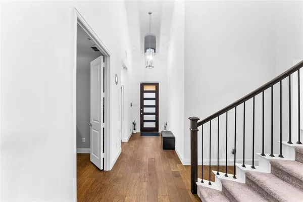 a view of a hallway with wooden floor and staircase
