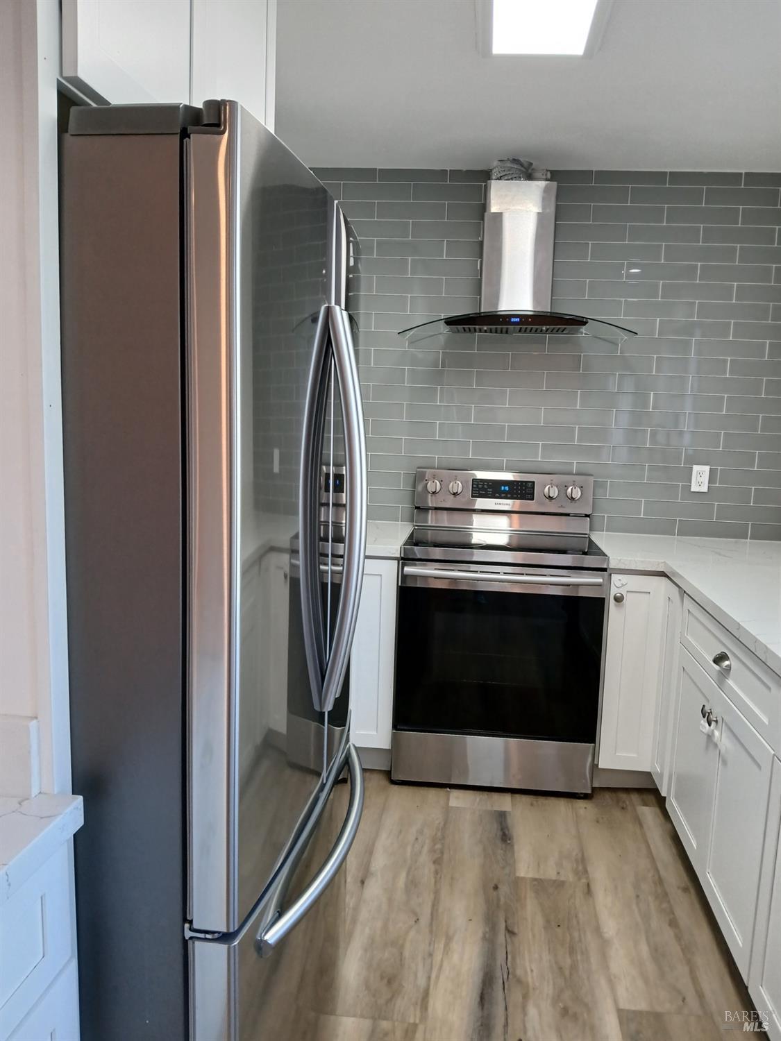 381 Wall Place Santa Rosa, CA 95401 - Photo 11 of 18 a kitchen with stainless steel appliances granite countertop a refrigerator a stove and a sink with wooden floor