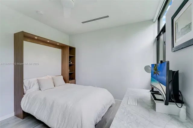 a bedroom with a bed a mirror and dresser