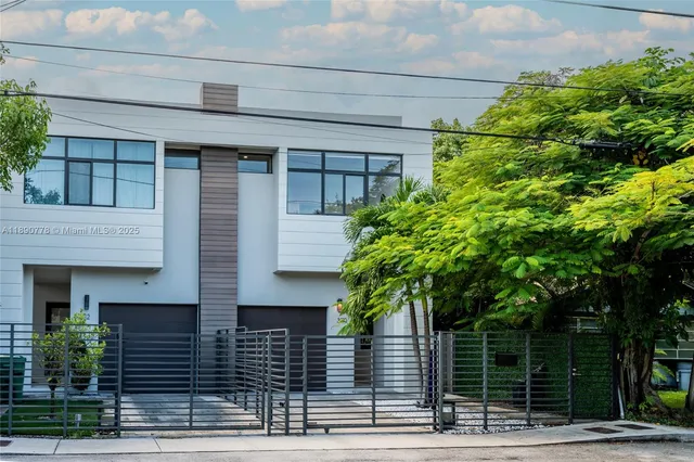 a front view of a house with plants