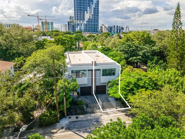 a aerial view of a house with plants and large trees