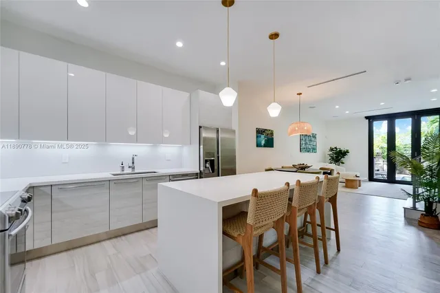 a large kitchen with kitchen island a dining table and chairs