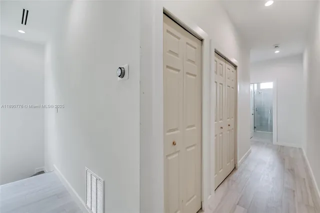 a view of a hallway with wooden floor