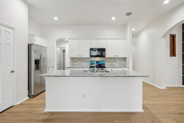 a kitchen with stainless steel appliances granite countertop a sink and a stove top oven