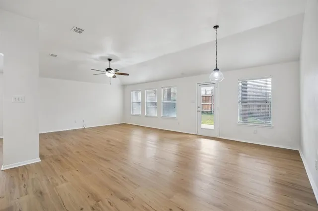 a kitchen with stainless steel appliances granite countertop a refrigerator a sink a stove a microwave and wooden floor