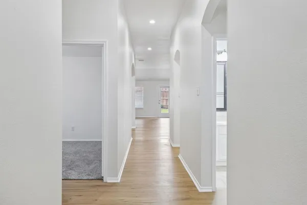 a view of a hallway with wooden floor