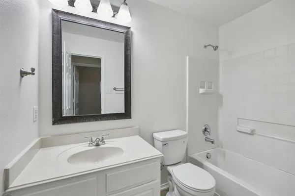 a bathroom with a sink toilet vanity and shower