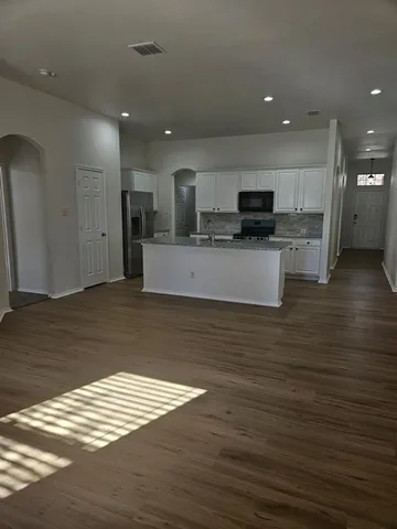 a view of kitchen with stainless steel appliances granite countertop a stove top oven a sink and a oven
