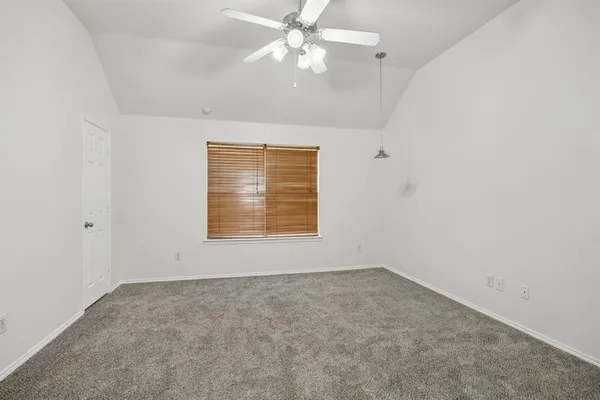 an empty room with a window and ceiling fan