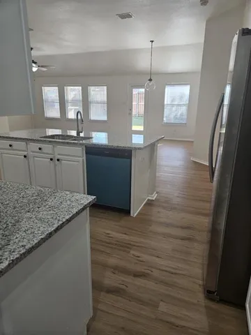 a kitchen with stainless steel appliances granite countertop a sink and a refrigerator