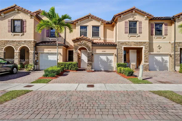 a front view of a house with a yard and a garage