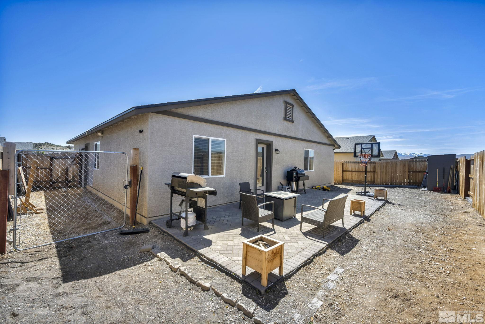 623 Yerington Drive Reno, NV 89506 - Photo 17 of 40 a view of a backyard with couches table and chairs under an umbrella with wooden fence