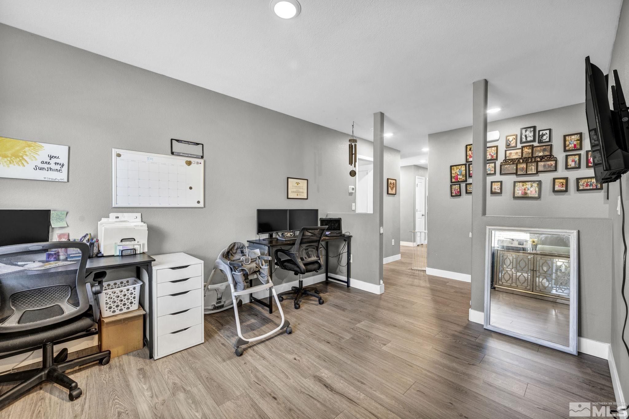 623 Yerington Drive Reno, NV 89506 - Photo 10 of 40 a workspace with furniture a wooden floor and a flat screen tv