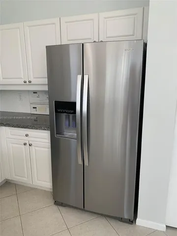a metallic refrigerator freezer sitting in a kitchen