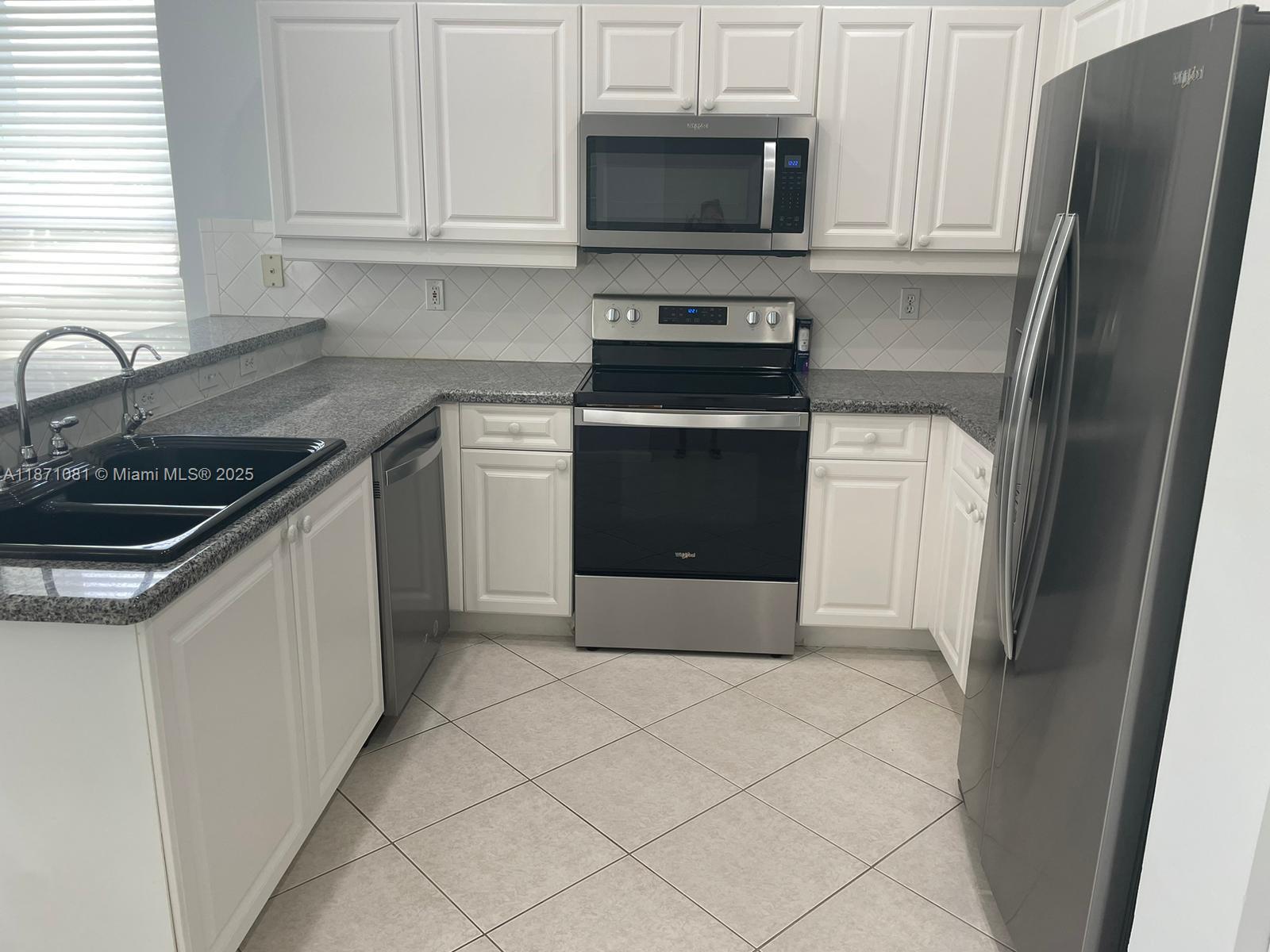 2145 Southwest 150th Avenue Miramar, FL 33027 - Photo 14 of 36 a kitchen with stainless steel appliances granite countertop a refrigerator stove and sink