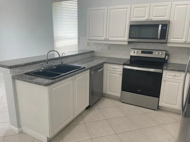 a kitchen with cabinets appliances and a sink