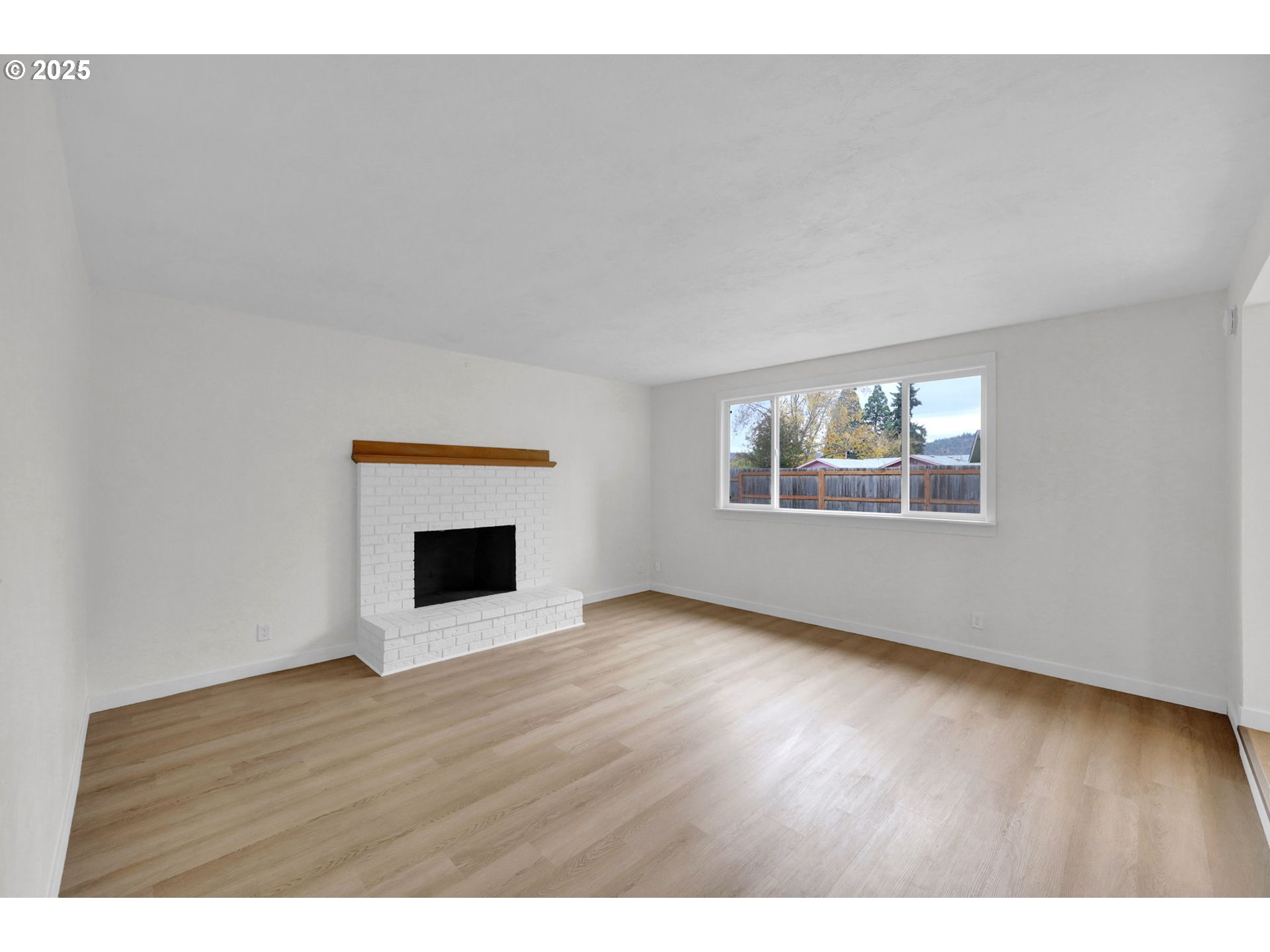 5266 D Street Springfield, OR 97478 - Photo 8 of 40 a view of an empty room with wooden floor fireplace and a window