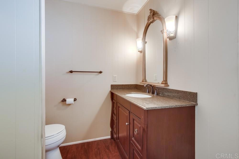 4993 Old Cliffs Road San Diego, CA 92120 - Photo 11 of 20 a bathroom with a granite countertop sink toilet and a mirror
