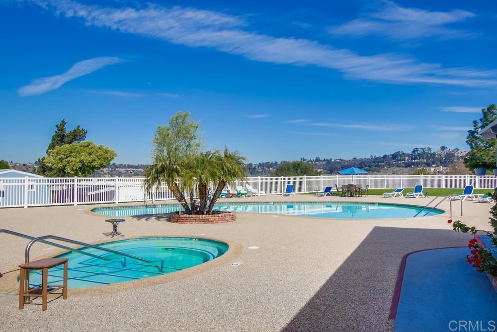 4993 Old Cliffs Road San Diego, CA 92120 - Photo 19 of 20 a view of a swimming pool with a lawn chairs under an umbrella