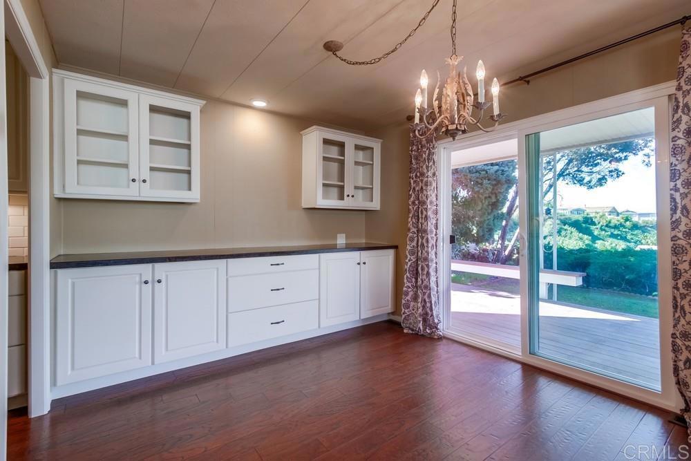 4993 Old Cliffs Road San Diego, CA 92120 - Photo 9 of 20 a view of a hallway with chandelier and wooden floor
