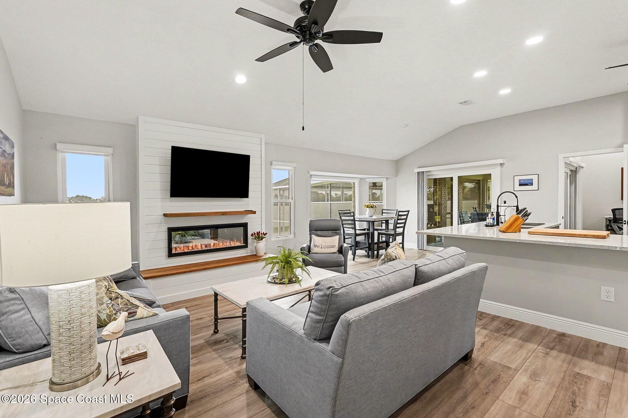 355 Lake View Lane Palm Bay, FL 32909 - Photo 9 of 49 a living room with furniture a fireplace and a flat screen tv