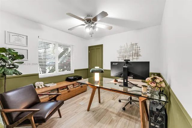 a view of a house with swimming pool and a big yard with palm trees