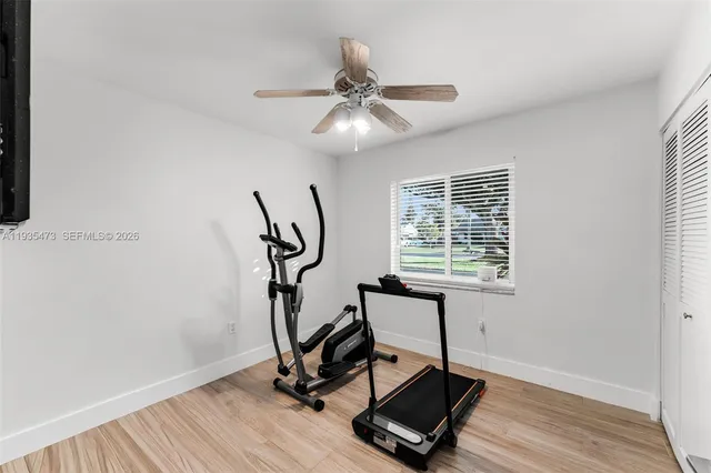 a view of an empty room with wooden floor and windows