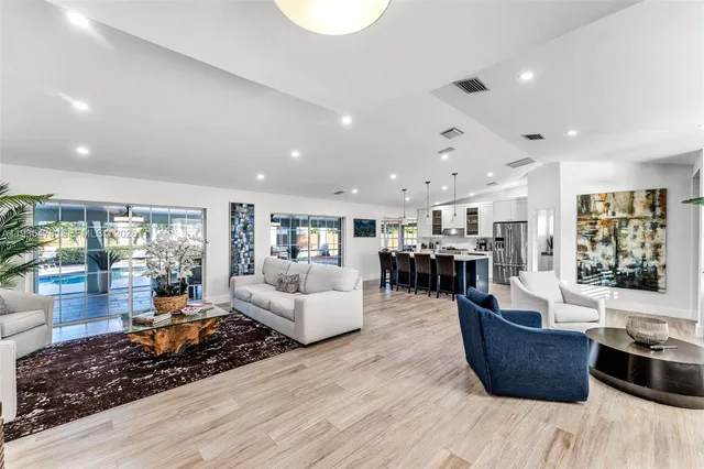 a kitchen with stainless steel appliances a dining table chairs stove refrigerator and microwave