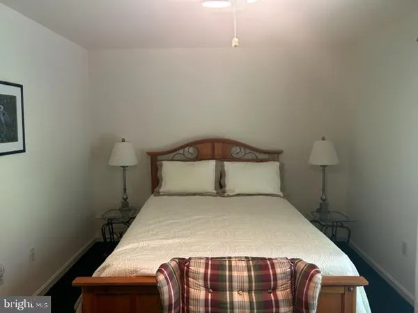 a bedroom with a bed and a lamp on the dresser