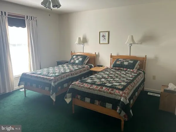 a bedroom with a bed and two windows