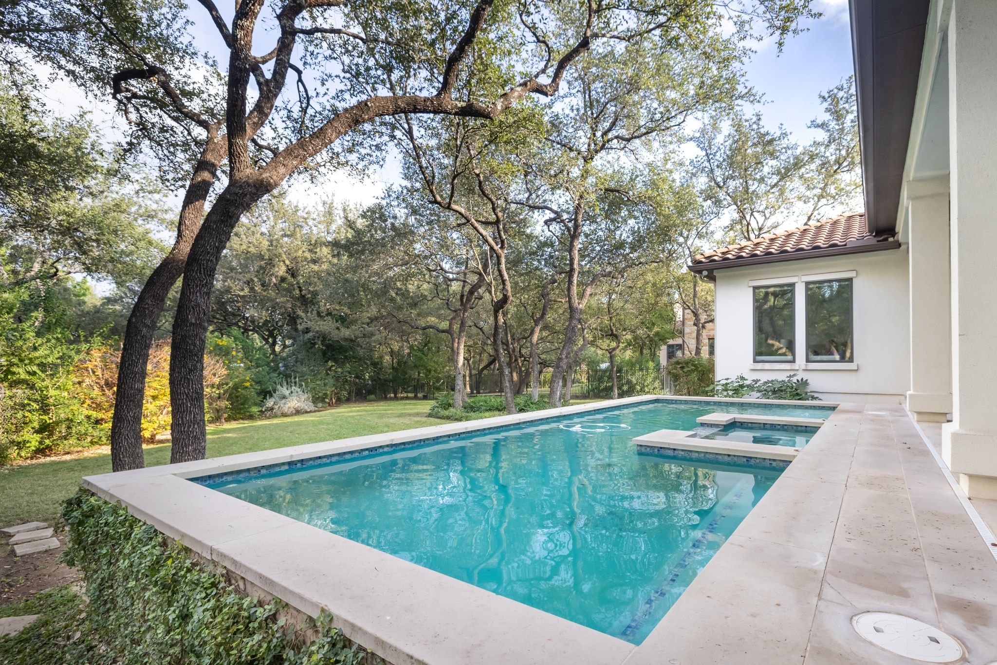 4720 Rockcliff Road, Unit 1 Austin, TX 78746 - Photo 7 of 39 An inviting in-ground pool and integrated spa provide relaxation amidst mature trees and a manicured yard.