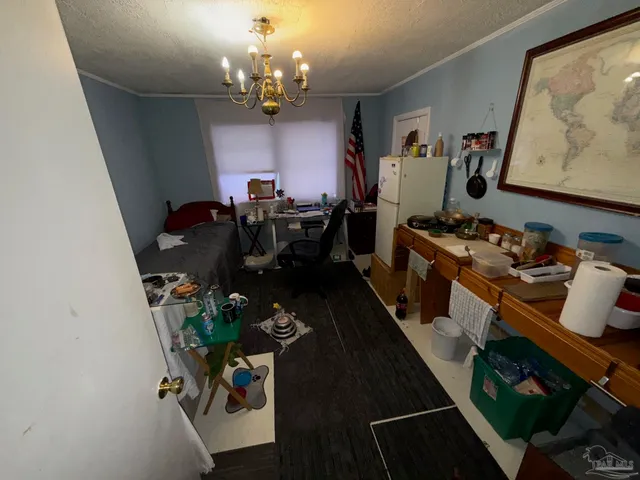a living room with furniture a chandelier and a dining table