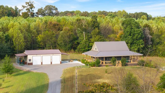 an aerial view of a house with garden space and trees