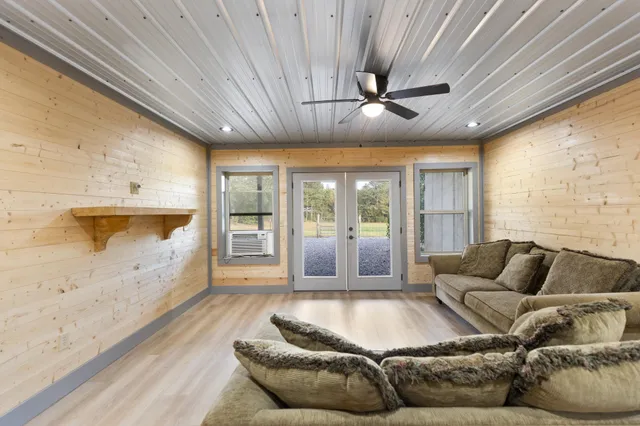 a living room with furniture floor to ceiling window and a flat screen tv