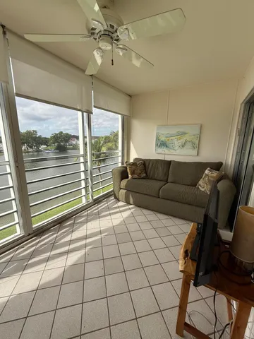a living room with furniture and a floor to ceiling window